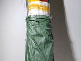 a large green umbrella wrapped in plastic on a shelf