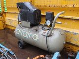 an air compressor sitting on the ground next to a yellow wall