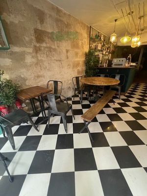 un sol à carreaux noirs et blancs, avec des tables et des chaises