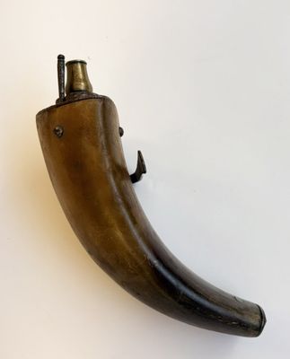 un objet en forme de corne posé sur une surface blanche