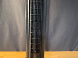 a fan sitting on top of a wooden table next to a remote