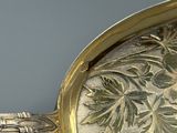 un gros plan d'une assiette en argent décorée de fleurs