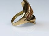 a close up of a gold ring with a red stone in it