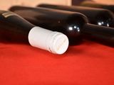 several bottles of wine are lined up on a red cloth