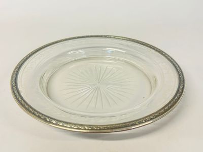 a glass plate with a silver rim on a white table