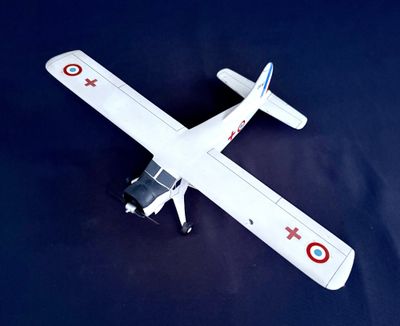 une maquette de petit avion posée sur une surface bleue