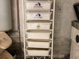 a stack of bins on a metal rack in a kitchen