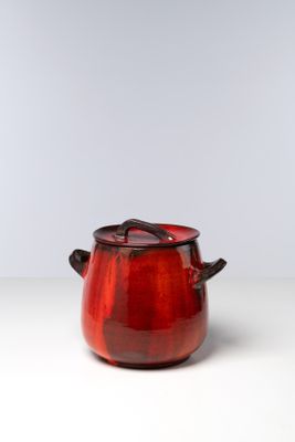 un gros plan d'un pot rouge posé sur une table