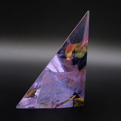 un gros plan d'un objet de forme triangulaire posé sur une surface noire