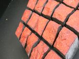 un gros plan d'une brique rouge sur une surface noire