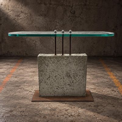 a table with a glass top sitting on top of a concrete block