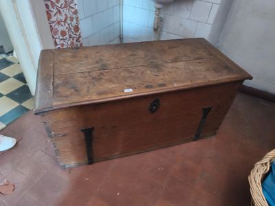 un coffre en bois posé par terre dans une salle de bains