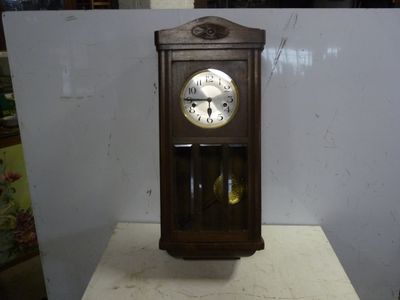a wooden clock sitting on top of a white table