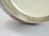 a close up of a plate with a flower design on it