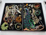 deux plateaux remplis de bijoux variés posés sur une table