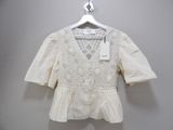 white blouse with crochet detail on shoulders and sleeves