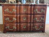 a wooden dresser with many drawers and a vase on top of it
