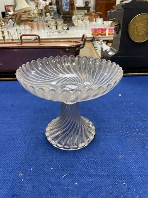 a glass bowl on a blue table with a clock in the background