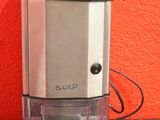 un moulin à café posé sur une table devant un mur rouge