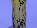 un vase jaune orné d'un tourbillon noir