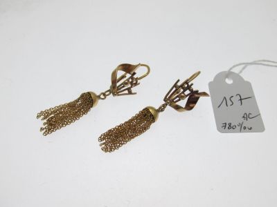 une paire de boucles d'oreilles dorées ornées de pompons, avec son étiquette de prix