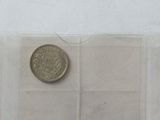 four different types of coins are displayed in a row on a white surface