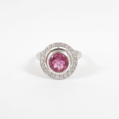 a close up of a pink and white diamond ring on a white surface
