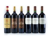 six bottles of wine are lined up on a white surface