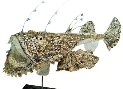 une sculpture représentant un poisson posée sur un socle, sur fond blanc