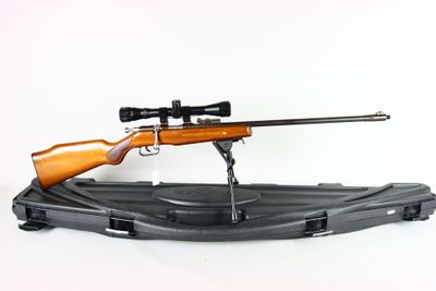 a rifle with a scope and a rifle stand on a white background
