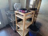 a kitchen with a wooden cart and a blue bucket on the floor
