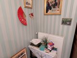 une photo d'une pièce avec une table et des tableaux accrochés au mur