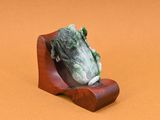 une figurine représentant une grenouille posée sur un socle en bois