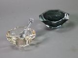 two glass ashtrays sitting on a table next to each other