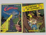 Deux bandes dessinées sont posées sur une table devant un mur blanc.