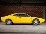 the yellow sports car is parked in the garage near a brick wall