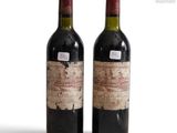 two bottles of wine sitting next to each other on a white surface