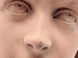 a close up of a statue of a child with a tie around his neck