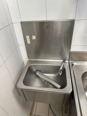 un lavabo situé dans un coin de la salle de bains, équipé d'un robinet