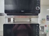 two microwaves stacked on top of each other in a kitchen