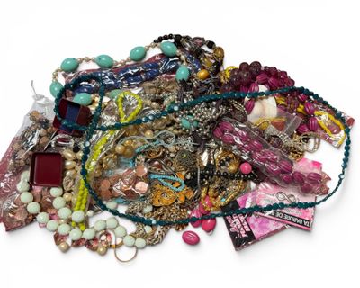 un tas de colliers et de bracelets de toutes sortes posés sur une surface blanche