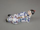 a figurine of a woman laying down on the ground