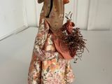 figurine of a woman with a straw hat holding a basket of flowers