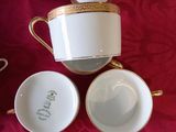 several cups and saucers sitting on a table with a red table cloth