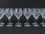six wine glasses lined up in a row on a black background