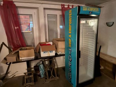 un réfrigérateur qui se trouve dans une pièce où il y a des cartons sur la table