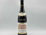 une bouteille de vin posée sur une table blanche