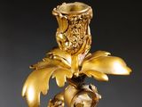 a gold candle holder with a flower on top of it