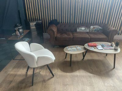 un salon avec un canapé, un fauteuil, une table basse et une télévision