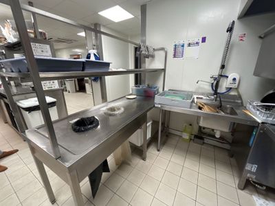 une cuisine avec des plans de travail en inox et un évier